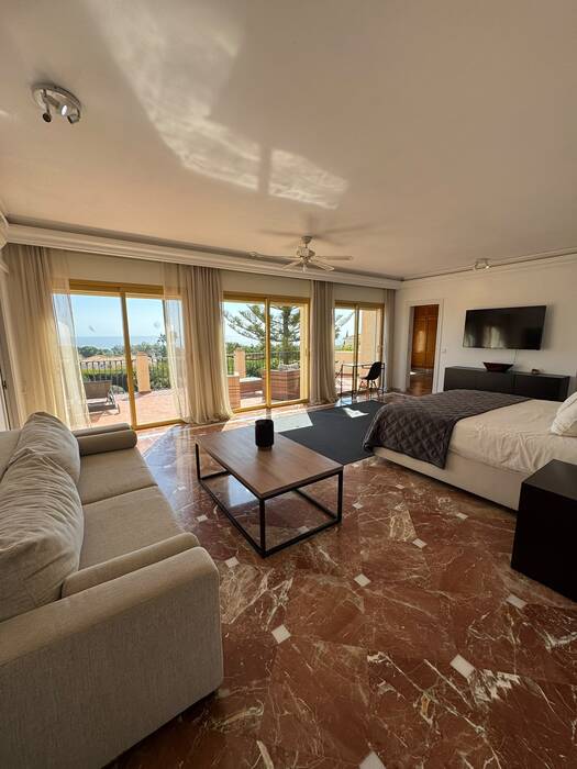 Suite living area with sofa, coffee table and balcony with sea view