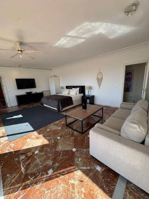 Spacious suite with bed, sofa and marble floor