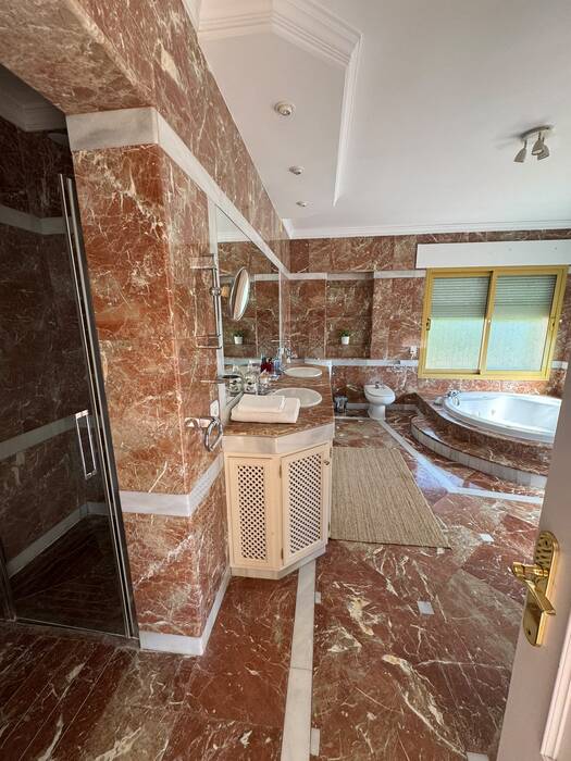 Marble bathroom with glass shower and corner bathtub
