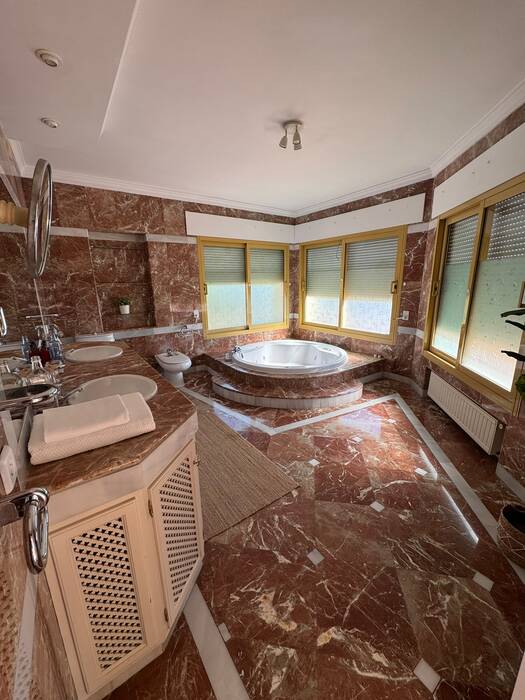 Marble bathroom with a raised circular jacuzzi and double vanity